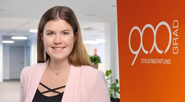 Frau mit langen braunen Haaren und rosafarbenem Blazer vor einer orangefarbenen Wand mit dem 900 GRAD Logo.